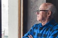 profile portrait of an elder Caucasian man looking out the window medium closeup indoor senior people concept Royalty Free Stock Photo