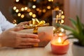 Profile portrait of faceless unknown female holding gift box with gold bow and ribbons in hands, preparing for New Year and Royalty Free Stock Photo