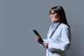 Profile portrait of female doctor holding clipboard on gray background, copy space Royalty Free Stock Photo