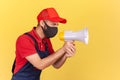 Profile portrait of handyman in unionalls and protective medical mask holding loudspeaker, warning about social distance and