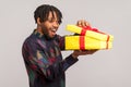 Profile portrait happy african man with dreadlocks opening gift box and peeping inside with toothy smile, satisfied with present Royalty Free Stock Photo