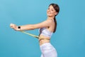 Profile portrait happy smiling woman in white sportswear measuring her waist with tape measure and smiling looking at camera, Royalty Free Stock Photo