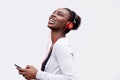 Profile of happy young african american woman listening to music with smart phone and headphones Royalty Free Stock Photo