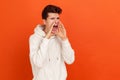 Profile portrait of hysterical young man loudly yelling in panic, holding hands near his mouth, teenager protest