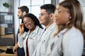 Profile portrait. Multiracial group of four doctors in lab coats standing in a row. Royalty Free Stock Photo