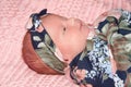 Profile portrait of newborn baby girl swaddled laying on pink blanket Royalty Free Stock Photo