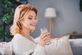 Profile portrait of positive peaceful person beaming smile good mood sit sofa hold glass mineral water enjoy domestic Royalty Free Stock Photo