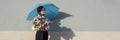 Profile portrait romantic teenage girl with bouquet of lilacs, with umbrella on gray wall background. Outdoor, copy space, Royalty Free Stock Photo