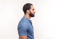 Profile portrait of serious self assured unsmiling man with beard in blue shirt seriously looking far away, confidence Royalty Free Stock Photo