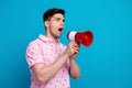 Profile portrait of speechless unsatisfied young man hold loudspeaker communicate empty space isolated on blue color Royalty Free Stock Photo