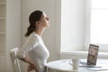 Profile portrait of a woman at desk stretching, backache positio Royalty Free Stock Photo