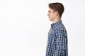 Profile portrait of young caucasian guy, boy with hairstyle and clean side of face, smiling and looking aside at empty Royalty Free Stock Photo