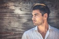 Profile portrait of young and handsome man on wooden background.