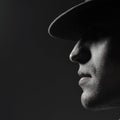 Profile portrait of a young man in a hat standing over dark gray background. Close up. Classic style. Copy-space. in bright ligh Royalty Free Stock Photo