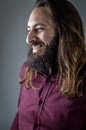 Profile portrait of a young middle eastern businessman with beard and long hair laughing cheerfully Royalty Free Stock Photo