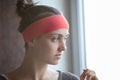 Profile portrait of a young woman alone looking out window. Royalty Free Stock Photo