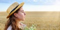 Profile portrait of young woman in straw hat and with bouquet of wild flowers Royalty Free Stock Photo