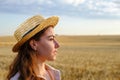 Profile portrait of young woman in straw hat in wheat field at dawn Royalty Free Stock Photo