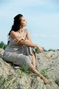 Profile of a relaxed calm woman silhouette sitting on the beach and watching sunset