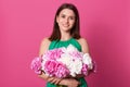 Studio shot of beautiful brunette girl holding with white and rose peonies in hands, attractive woman looking at camera, female Royalty Free Stock Photo