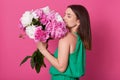 Profile shot of beautiful brunette girl holding with white and rose peonies, attractive woman with big bouquet, female smells Royalty Free Stock Photo