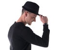 Profile shot of young man smiling, touching fedora hat Royalty Free Stock Photo