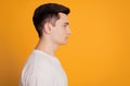 Profile side of confident serious young male enterpreneur isolated over yellow background