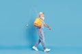 Profile side photo of aged man happy positive smile go walk fisherman spinning rod isolated over blue color background