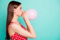 Profile side photo of astonished girl inflating balon looking wondering wearing polka dot dress singlet isolated over