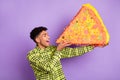 Profile side photo of attractive afro american man eat paper pinata big pizza isolated on violet color background