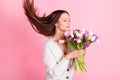 Profile side photo of calm sweet cute young lady smell flowers hold hands hair fly isolated on pink color background Royalty Free Stock Photo