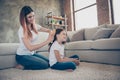 Profile side photo of charming lady having foxy ginger brushing hair sitting house room indoors wearing white t-shirt