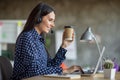 Profile side photo of charming woman hold takeout coffee cup work laptop call center wear headset mic indoors in office Royalty Free Stock Photo