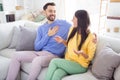 Profile side photo of cheerful young married couple happy positive smile sit couch speak talk laugh indoors Royalty Free Stock Photo