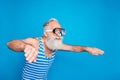 Profile side photo of concentrated pensioner swimming in glasses wearing striped bathing suit  over blue Royalty Free Stock Photo