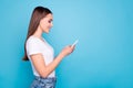 Profile side photo of cute lady looking into her device smiling searching news wearing white t-shirt denim isolated over