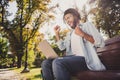 Profile side photo of dark skin happy victorious man sit bench look computer win outside in outdoors park