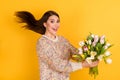 Profile side photo of excited happy lady give get flowers tulips empty space fly hair wind isolated on yellow color Royalty Free Stock Photo