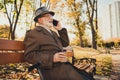 Profile side photo of grey white hair positive old man enjoy rest town park autumn outside relax sit bench call talk Royalty Free Stock Photo