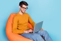 Profile side photo of young business man happy smile work laptop typing project sit chair  over blue color Royalty Free Stock Photo