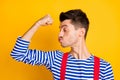 Profile side photo of young handsome man sailor showing kissing biceps muscles  on yellow color background Royalty Free Stock Photo