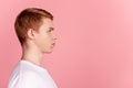 Profile side photo of young man serious clever look empty space ginger hair isolated over pink color background