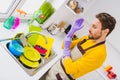 Profile side photo of young man wear violet rbber gloves prepare washing dishes sink kitchen dirty indoors Royalty Free Stock Photo