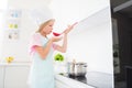 Profile side photo of young preteen girl taste dish yummy saucepan culinary cuisine healthy food indoors