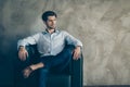 Profile side portrait of serious minded elegant businessman sit on black armchair look copyspace dream think job work Royalty Free Stock Photo