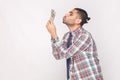 Profile side view of cheerful rich handsome bearded young stylish businessman in colorful checkered shirt standing and air Royalty Free Stock Photo