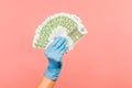 Profile side view closeup of human hand in blue surgical gloves holding and showing fan of European union Euro money in hand