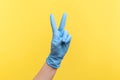 Profile side view closeup of human hand in blue surgical gloves showing victory, peace sign or number 2 with fingers Royalty Free Stock Photo