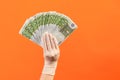 Profile side view closeup of human hand in white surgical gloves holding and showing fan of European union Euro money in hand