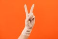 Profile side view closeup of human hand in white surgical gloves showing victory, peace sign or number 2 with fingers Royalty Free Stock Photo